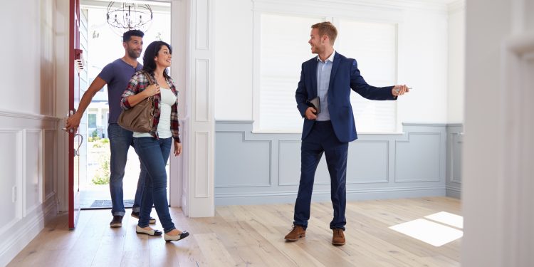 Realtor Showing Hispanic Couple Around New Home