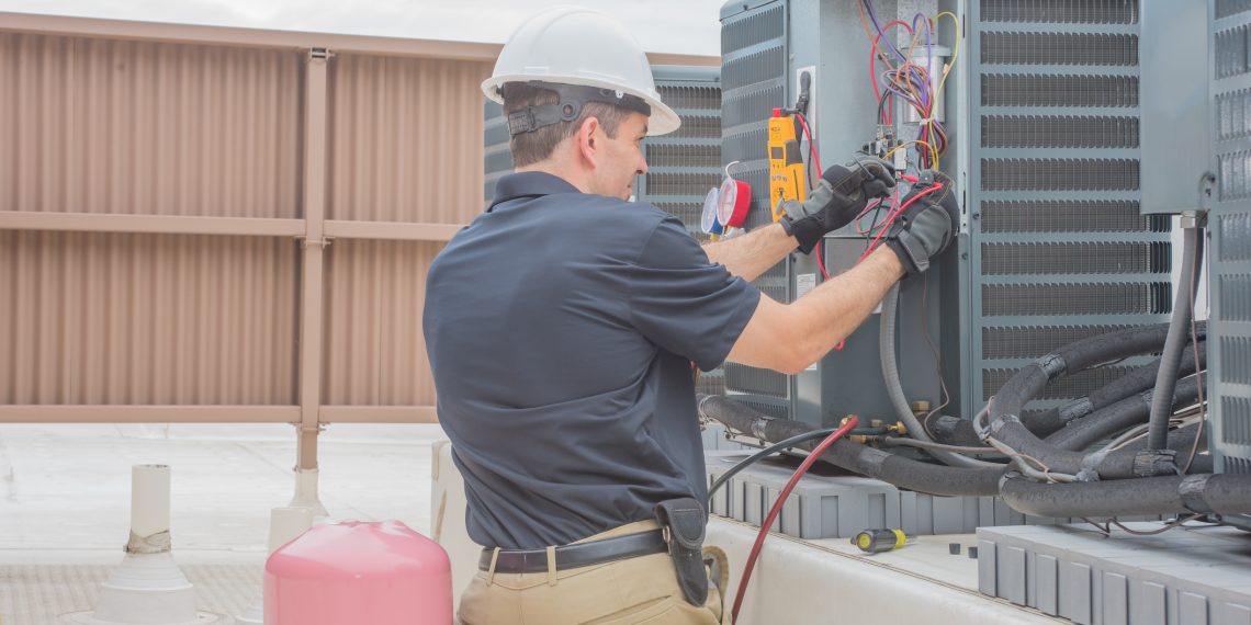 Technician checking for power on a rooftop condensing unit.