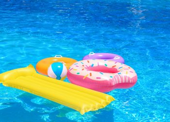 Inflatable rings, mattress and ball in blue swimming pool