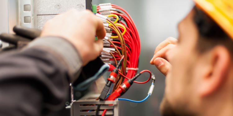 Electrician engineer tests electrical installations and wires on relay protection system. Bay control unit. Medium voltage switchgear