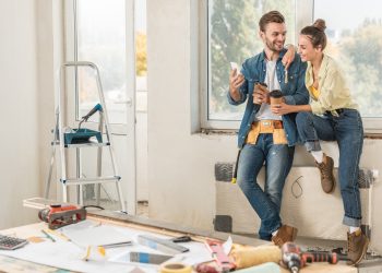 happy young couple holding paper cups and using smartphone repairment