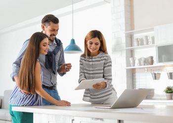 Female real estate agent working with couple, indoors