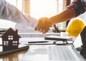 Client shaking hands with contractor after confirm blueprint to renovate house.