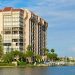 Beautiful waterside waterfront condominium luxury homes on a waterway with boats at the dock and green palm trees