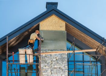 Construction,Worker,Installing,Stone,Veneer,On,A,Modern,Home