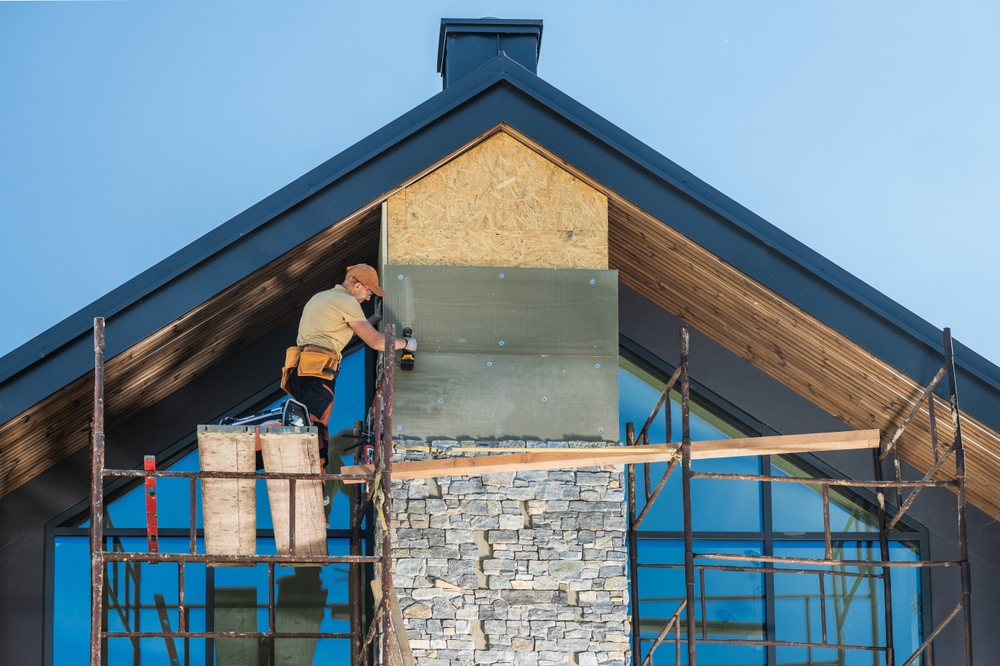 Construction,Worker,Installing,Stone,Veneer,On,A,Modern,Home