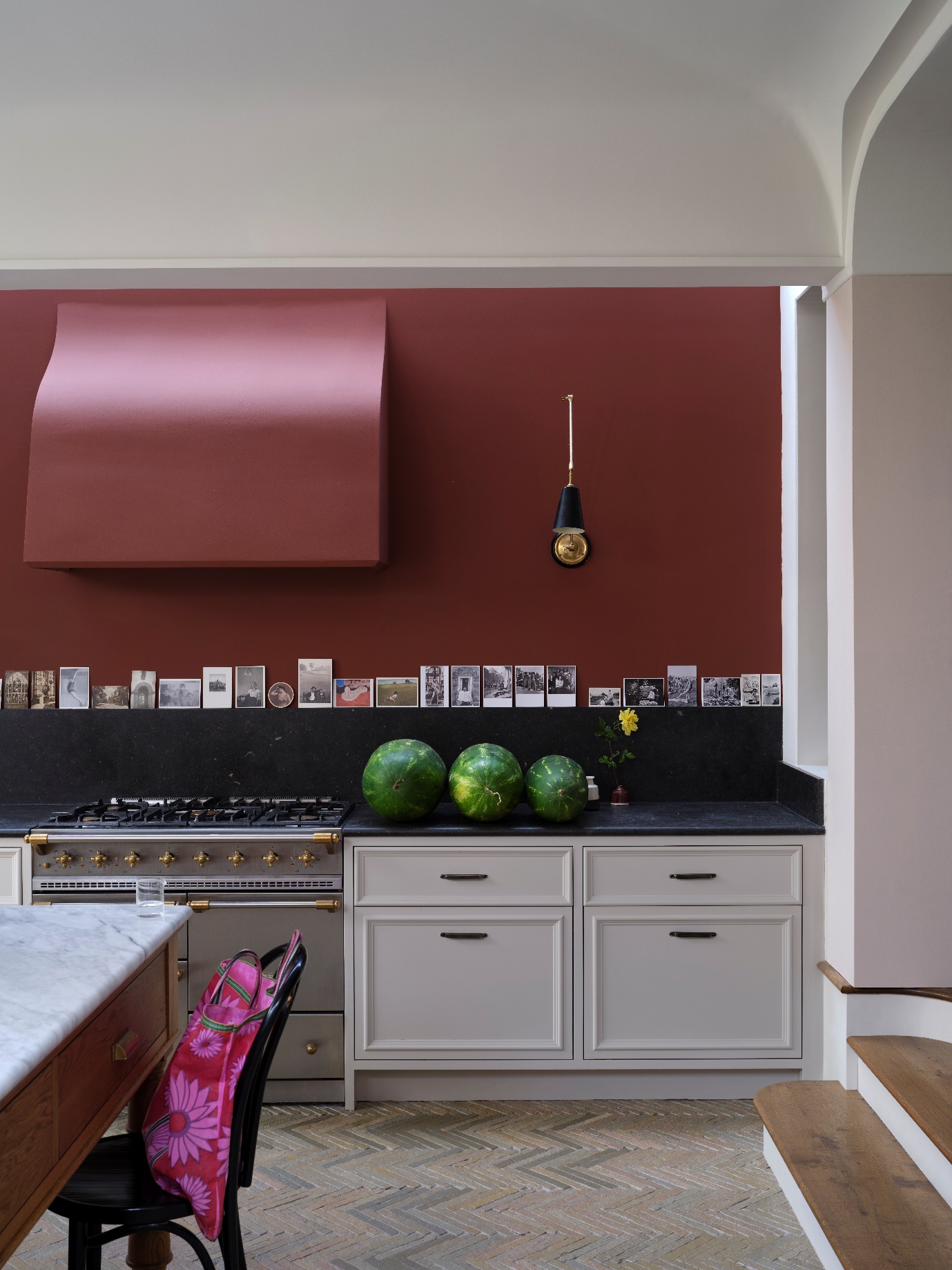 A kitchen with white cabinets and red walls