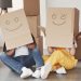 Cute smiles on boxes that is on the heads. happy couple together in their new house. conception of moving Free Photo