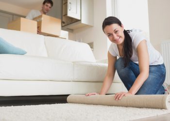 Two young people furnishing the living room of new home