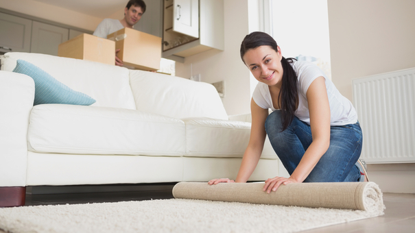 Two young people furnishing the living room of new home