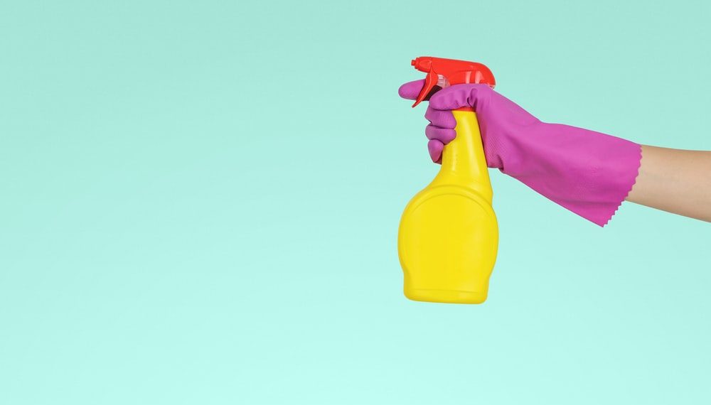 person holding yellow plastic spray bottle