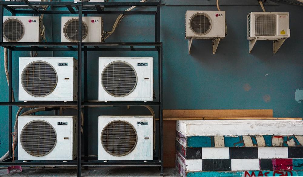 white and black box fan on brown wooden shelf