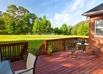 Residential backyard deck overlooking lawn and lake