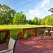 Residential backyard deck overlooking lawn and lake
