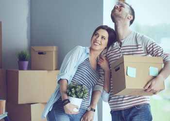 Happy young couple unpacking or packing boxes and moving into a new home.