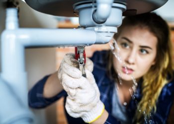 Woman fixing kitchen sink