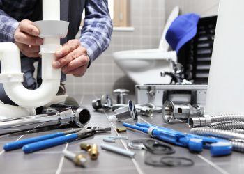 plumber at work in a bathroom, plumbing repair service, assemble and install concept