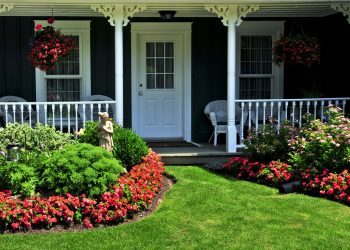 Landscaped front yard of a house with flowers and green lawn