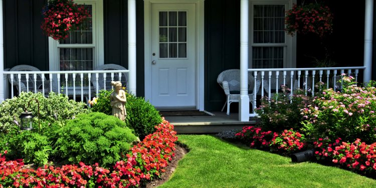 Landscaped front yard of a house with flowers and green lawn